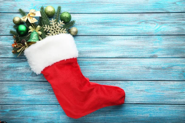 Köknar-ağaç dalları ve Noel dekorasyonları ahşap masa üzerinde çorap kırmızı