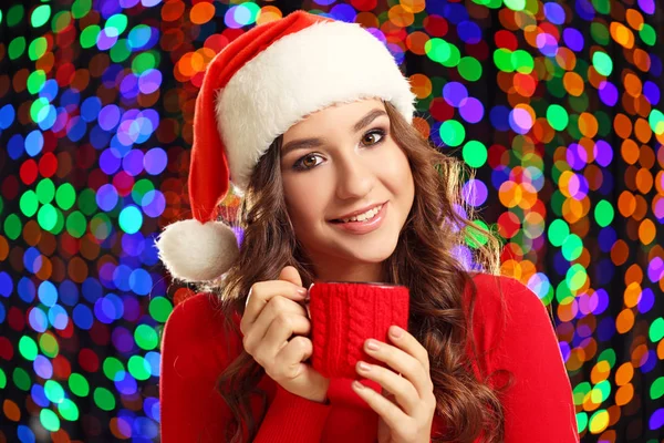 Young Woman Santa Hat Cup Tea Lights Background — Stock Photo, Image