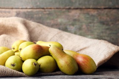 Olgun ve tatlı armut gri ahşap masa üstünde çul ile