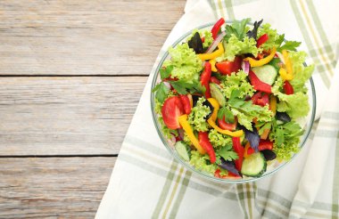 Gri ahşap masa üzerinde cam kase sebze salatası