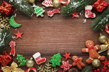Noel gingerbread çerezleri köknar-ağaç dalları ve ahşap masa üzerinde baubles ile
