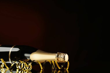 Siyah arka plan üzerine şerit ile şampanya şişesi