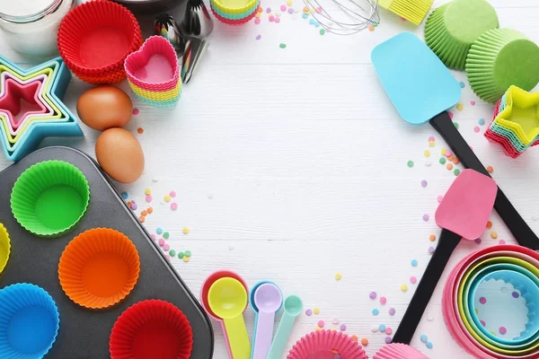 Beyaz Ahşap Masa Üzerinde Farklı Mutfak Gereçleri Talepleriyle Boş Cupcake — Stok fotoğraf