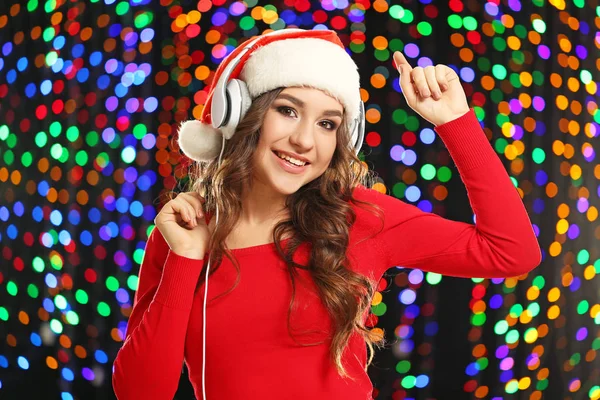Jonge Vrouw Kerstmuts Met Een Koptelefoon Achtergrond Verlichting — Stockfoto