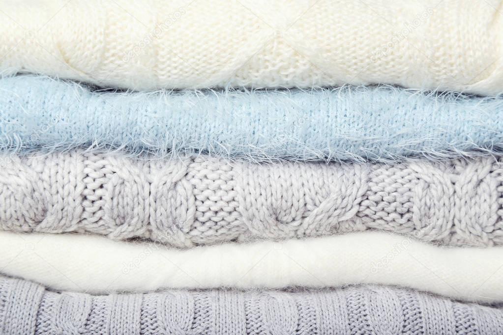 Stack of knitted sweaters background