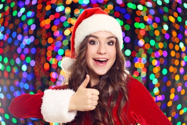 Noel Baba şapkası ışıklar arka plan üzerinde genç kadın