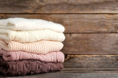 Örme kazak gri ahşap masa üzerinde yığını