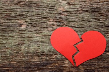 Gri ahşap masa üzerinde kırık kırmızı kalp