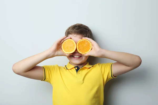 Portret Van Jonge Jongen Met Oranje Vruchten Grijze Achtergrond — Stockfoto