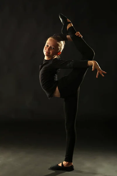 Jeune fille gymnaste sur fond noir — Photo