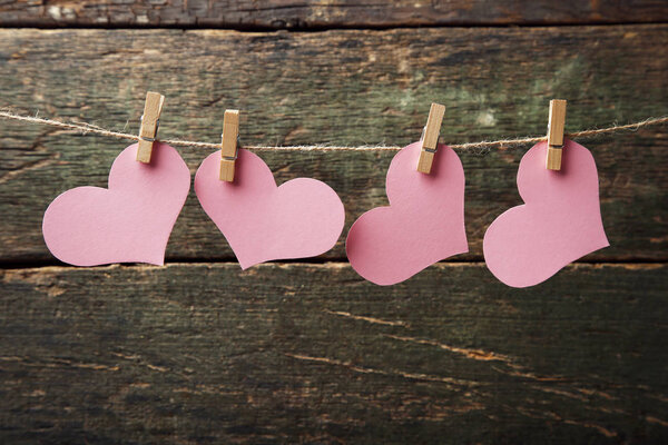 Pink paper hearts hanging on rope 