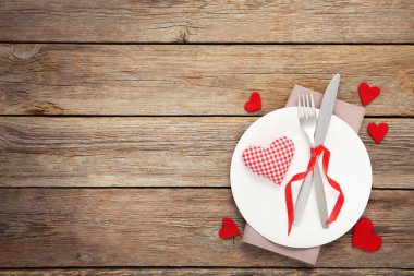 Fork and knife with heart on white plate clipart