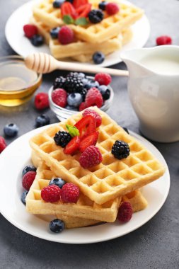 Sweet waffle with berries, milk and honey clipart