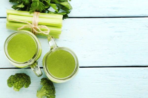 Bottles of juice with broccoli and celery — Stock Photo, Image