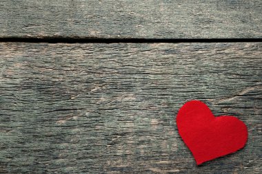 Gri ahşap masa üzerinde kırmızı kalp