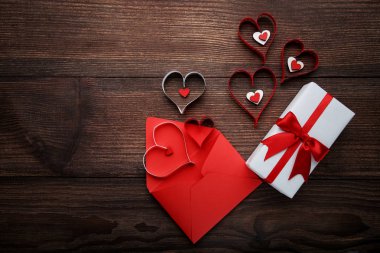 Hediye kutusu ile kalpleri ve kırmızı zarf üzerinde ahşap masa