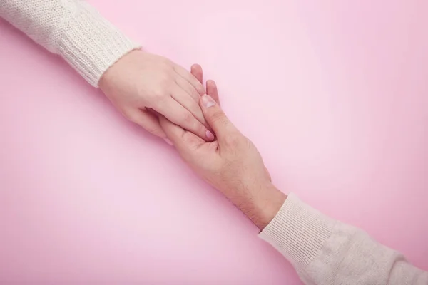 ピンクの背景にお互いを持っている女性と男性の手 — ストック写真