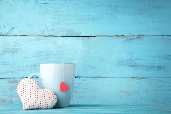 Ahşap masa üzerinde kumaş kalp ile çay