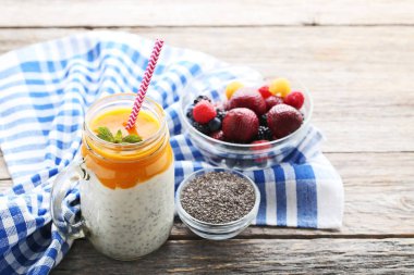 Chia puding kavanoza gri ahşap masa üzerinde çilek ile