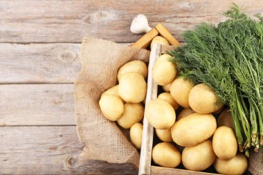 Patates dereotu ve sarımsaklı gri ahşap masa üzerinde sandık