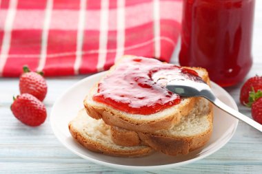 ahşap masa üzerinde çilek reçelli ekmek