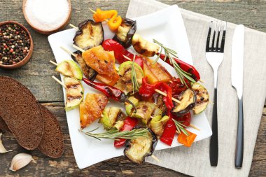 Tabak çatal, bıçak ve ahşap masa ekmek ızgara sebze