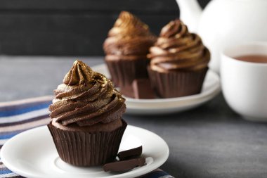 Plaka gri ahşap masa üzerinde çikolata cupcakes