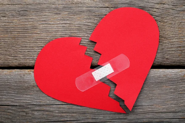 Ahşap Masa Yapışkanlı Bandaj Ile Kırmızı Kağıt Kalp — Stok fotoğraf