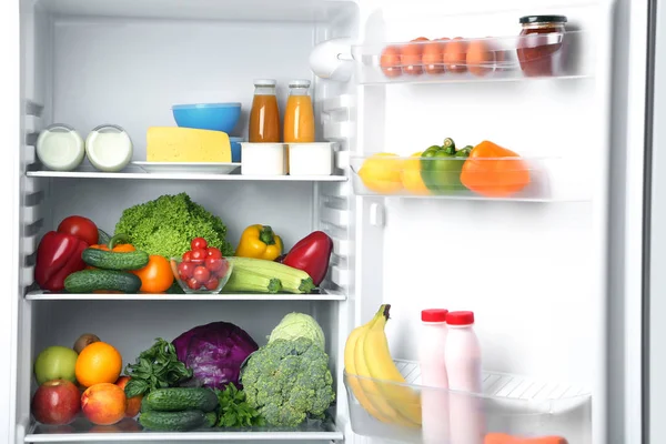 Open fridge full of vegetables and fruits