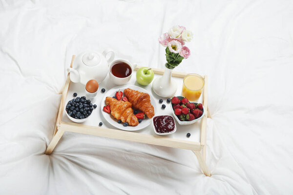 Вкусный завтрак в постели на деревянном подносе
