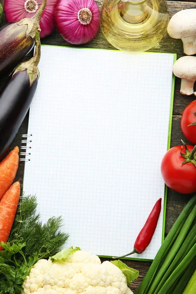 木桌上有蔬菜的空白菜谱书 — 图库照片