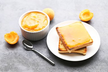 Ekmek tost gri ahşap masa üzerinde kase kayısı reçeli