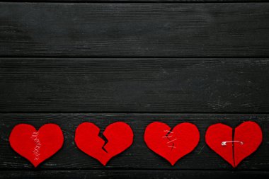 Siyah ahşap masa üzerinde kırık kırmızı Kalpler
