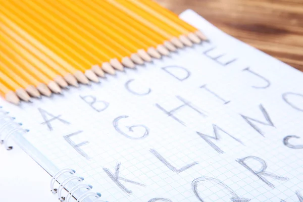 Handgeschreven Alfabet Notitieblok Met Potloden Bruin Houten Tafel — Stockfoto