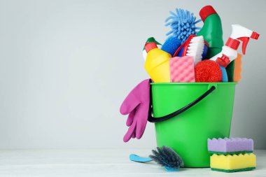 Şişe ile deterjan ve temizlik araçları gri arka plan üzerinde