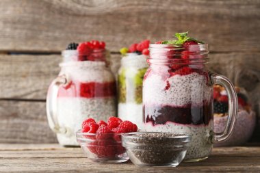 Chia pudding kavanozların üzerinde ahşap masa içinde çilek ile