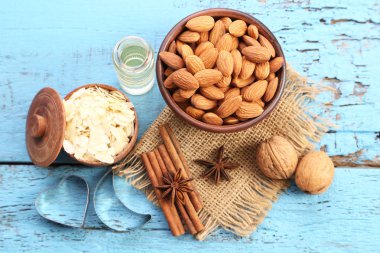 Badem kase şişe ile mavi ahşap masa üzeri yağlıboya