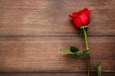 Kahverengi ahşap masa üzerinde kırmızı gül