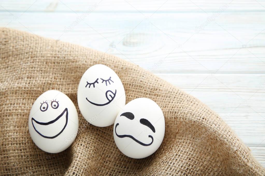 Eggs with funny faces on brown sackcloth