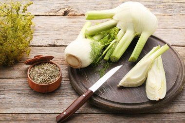 Olgun rezene Ampüller ve gri ahşap masa üzerinde kase kuru tohum