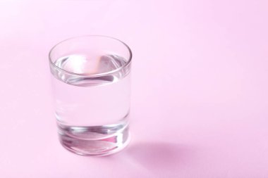 Pembe bir arka plan üzerinde su ile cam