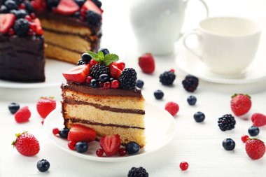 Çilek plaka üzerinde ahşap masa ile çikolatalı kek parçası