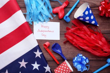 Amerikan bayrağı, üfleyici, lastik balon ve kağıt ile ahşap masa üzerinde yazıt Mutlu Bağımsızlık günü