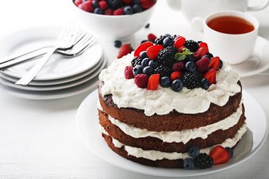 Fincan çay ve Beyaz ahşap masa Tabaklarda lezzetli çikolatalı bisküvi kek