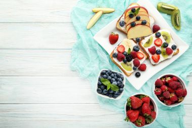 Çilek plaka üzerinde beyaz ahşap masa ile tost ekmeği