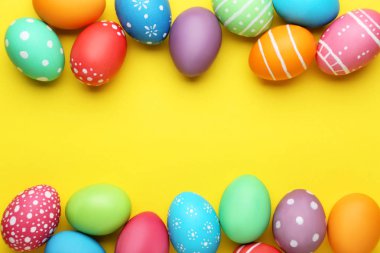 sarı arka plan üzerinde renkli Paskalya yumurtaları
