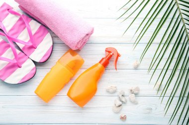 Flip flop ve Beyaz ahşap masa havluda güneş kremi