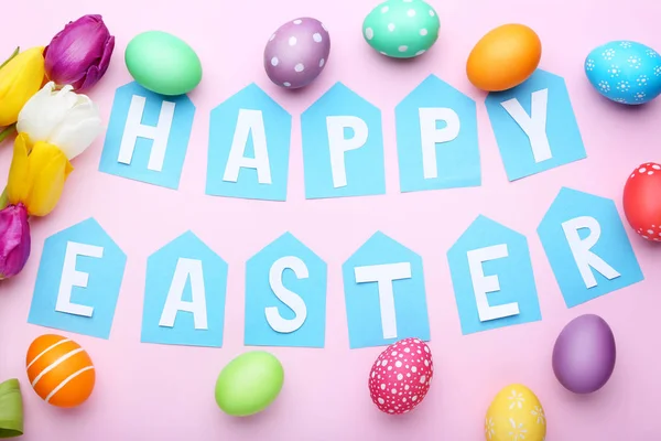 Yazıt mutlu Paskalya yumurta ve Lale pembe bir arka plan üzerinde