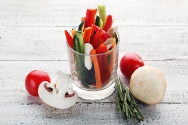 Ahşap masa üzerinde bardaklarda sebze dilimlenmiş