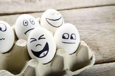 Yumurta karton paket ahşap masa üzerinde komik yüzü olan